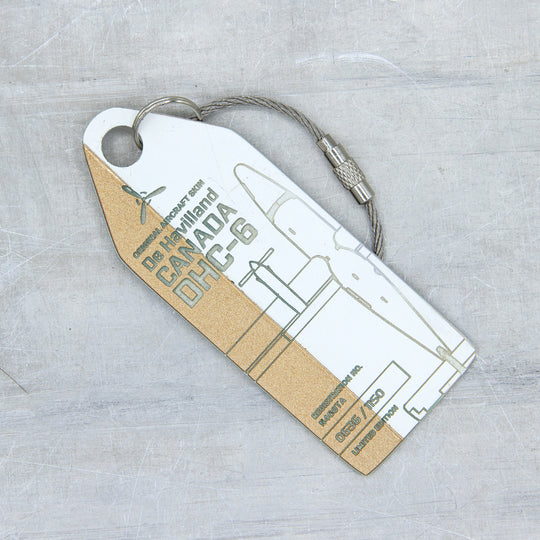 Close-up of gold and white engraved Aviationtag from de Havilland DHC-6 Twin Otter, featuring serial number and aircraft registration