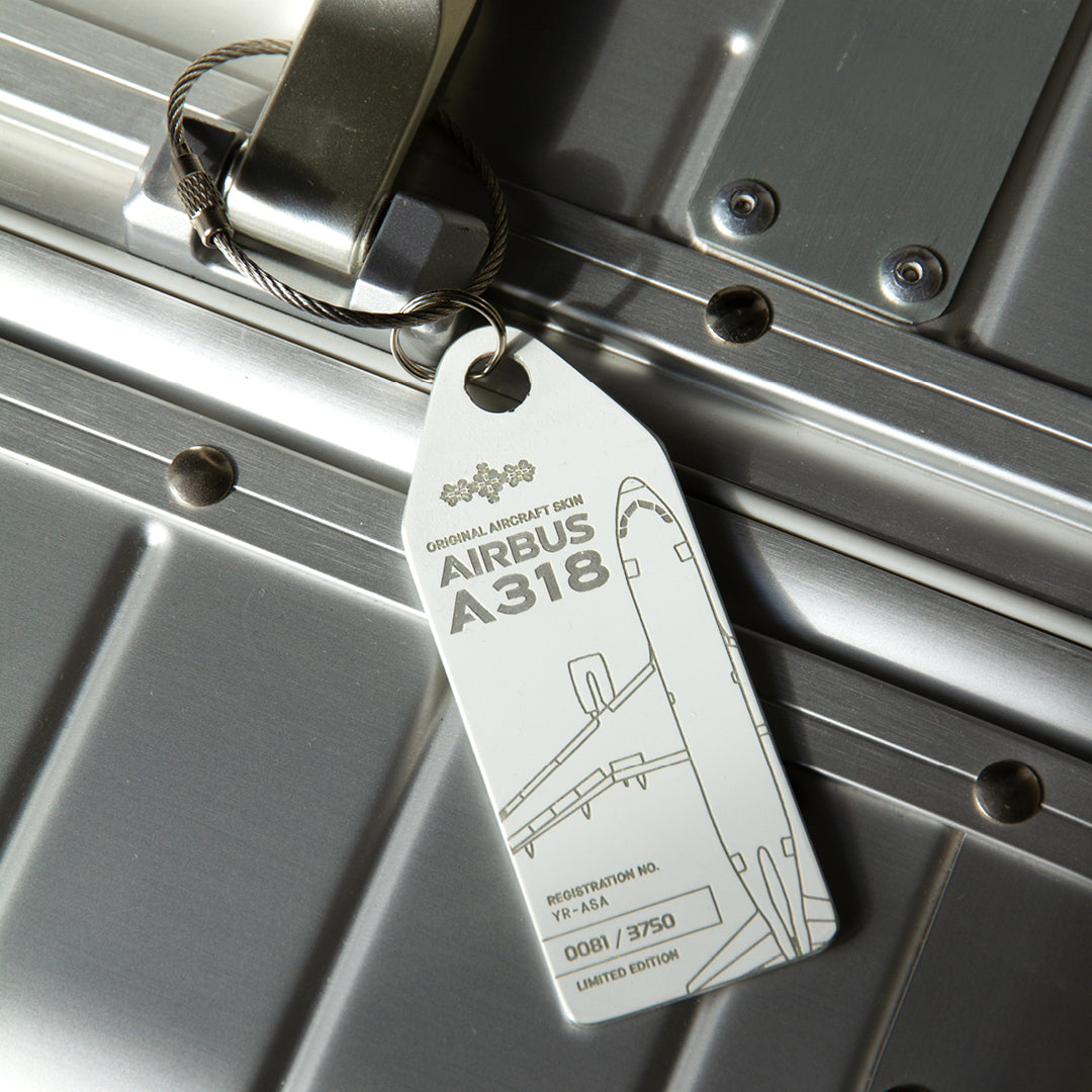 10 Years of Aviationtag - Airbus A318 YR-ASA aircraft tag edition ex Tarom. Image shows the white plane tag on a silver suitcase 