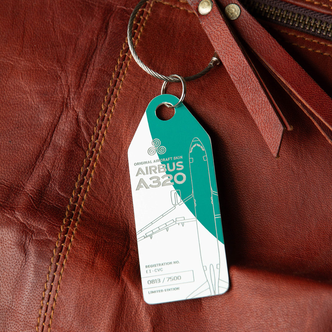 Green and white Aviationtag upcycled from former Aer Lingus Airbus A320EI-CVC - authentic aircraft tag as a bag tag on a brown messenger bag