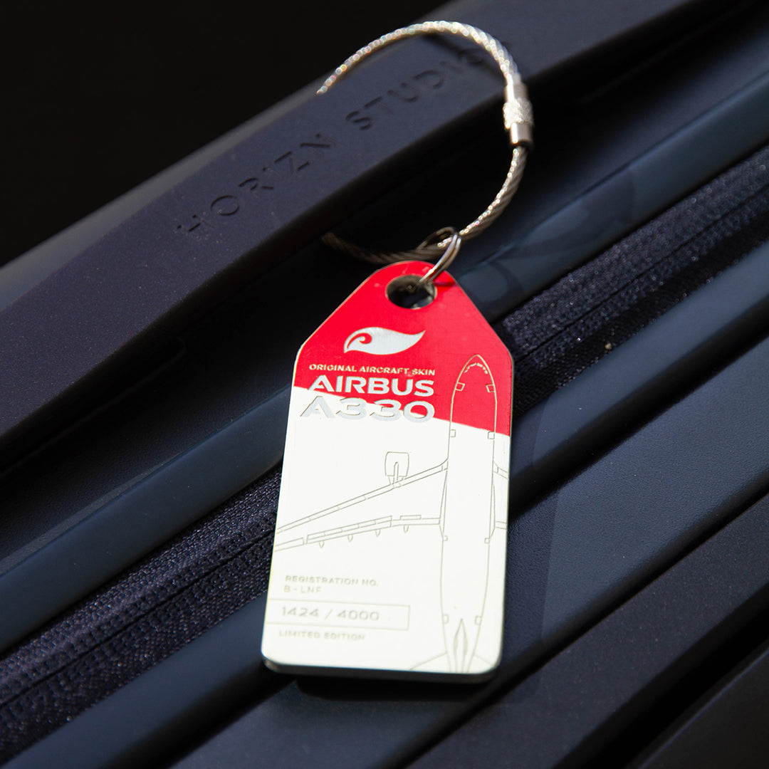 Lifestyle shot: Aviationtag keychain on luggage—plane tag from Hong Kong AIrlines Airbus A330 B-LNF