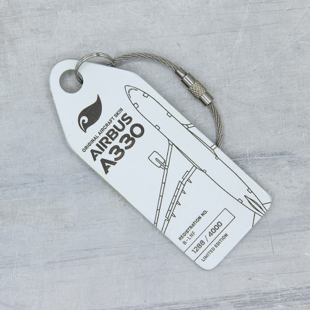 Close-up of white aircraft tag cut from upcycled fuselage panel—Aviationtag from Airbus A330 B-LNF; authentic patina and precise engraving 